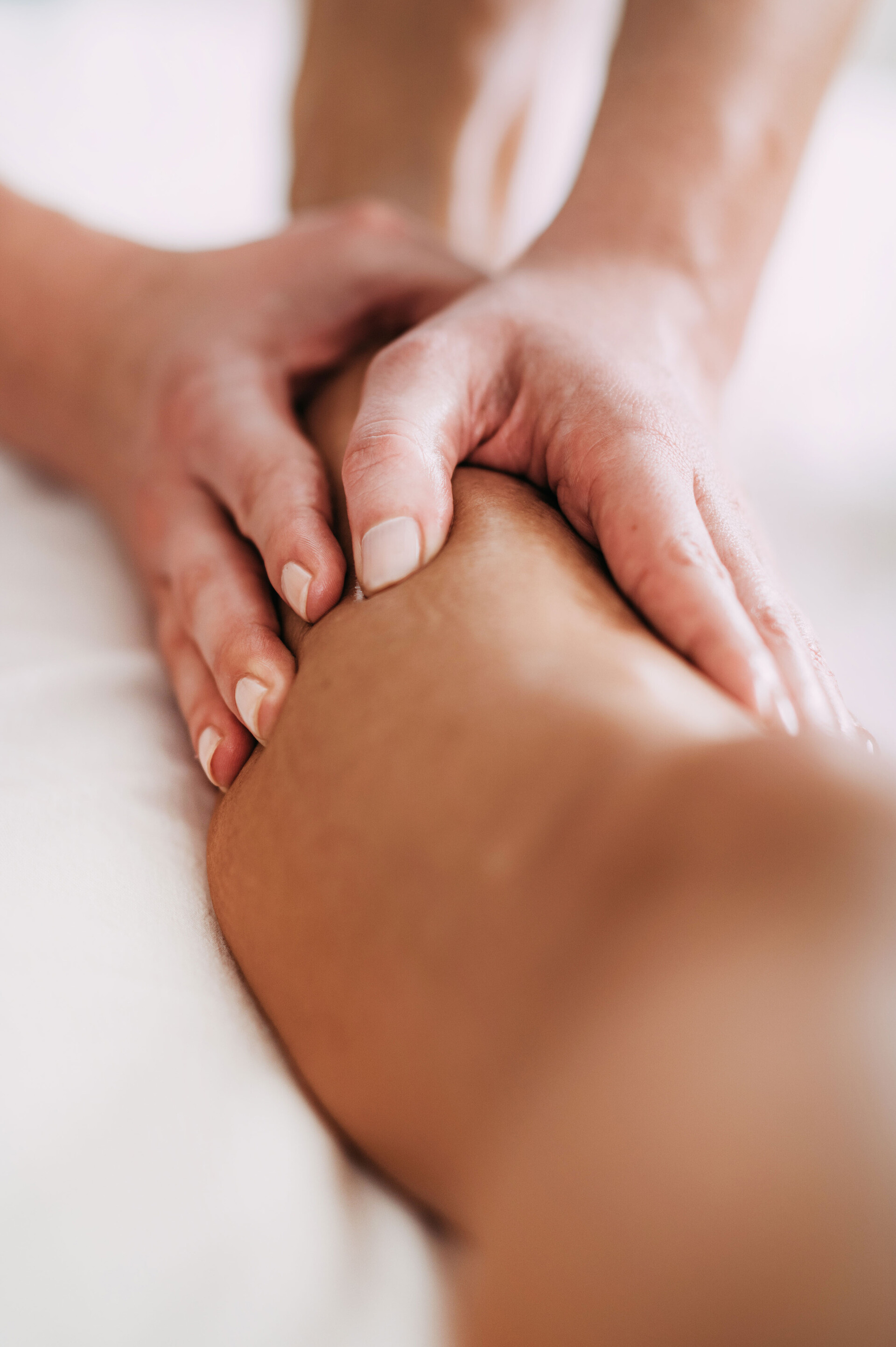 Hautprodukte können auch zur Massage eingesetzt werden, wie dieses Bild von zwei massierenden Händen auf einer Wade zeigt.