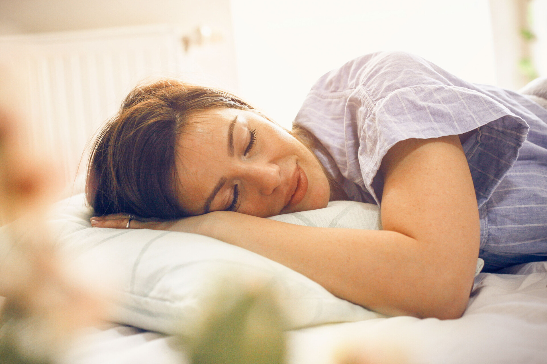 Diese junge Frau schläft auf der Seite und zeigt, dass Schlaf ein Mittel zur Entspannung ist.