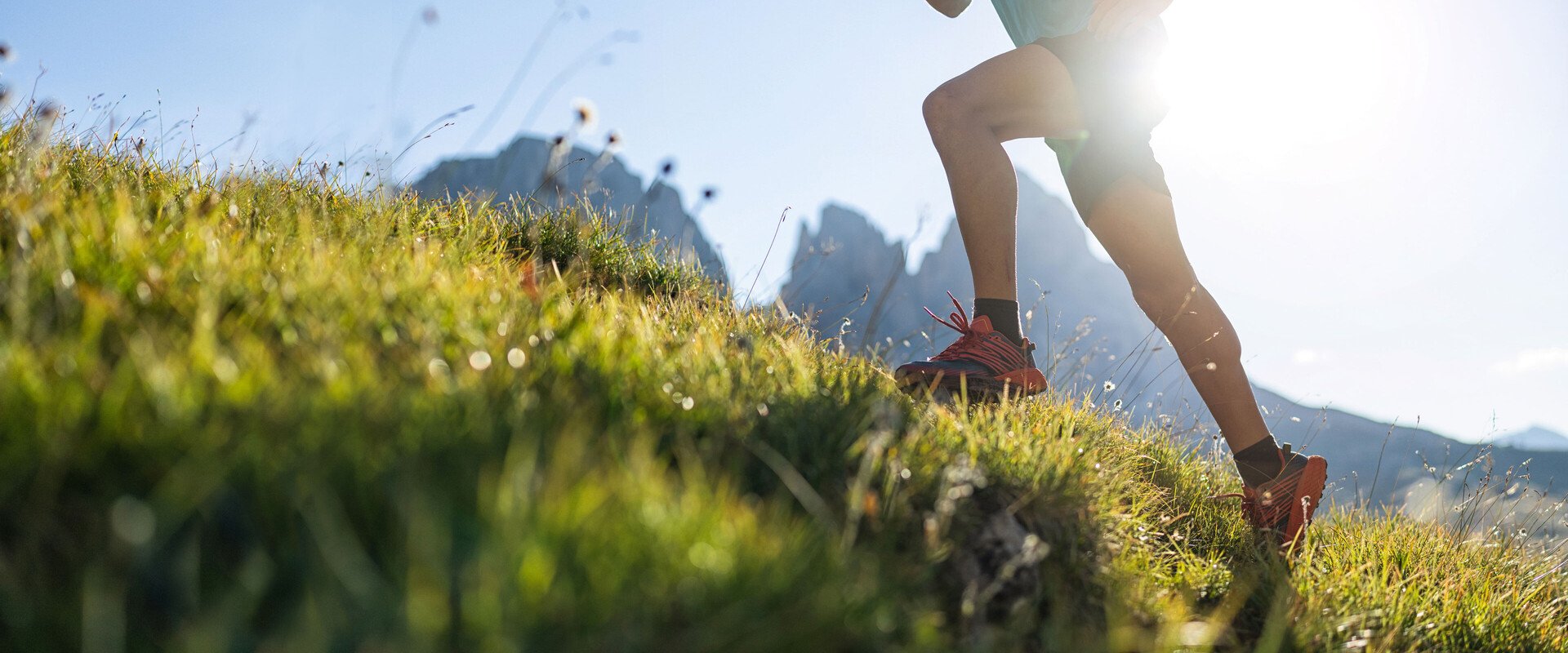 Die Beine eines Trailrunners auf einem Bergrücken. Das Bild leitet die Produktkategorie Sixtus Sport ein.