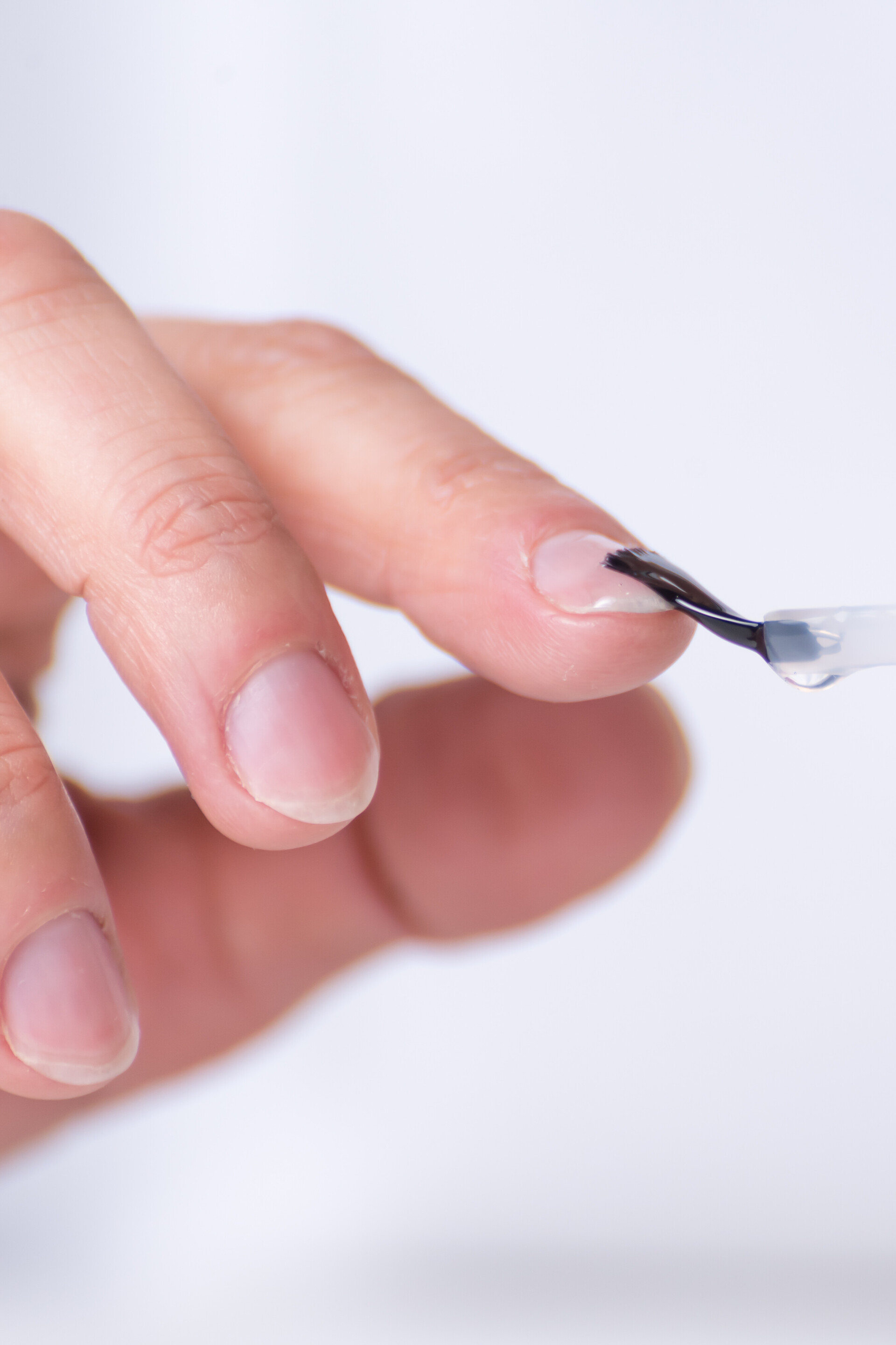 Eine Frau pinselt sich Sixtus Nagelöl zur Nagelpflege auf die Fingernägel